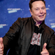 Elon Musk smiles and gives two thumbs up.